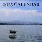 The 2025 calendar cover photo features a calm, but foggy, view of the Cousins Island bridge with a small boat in the foreground.